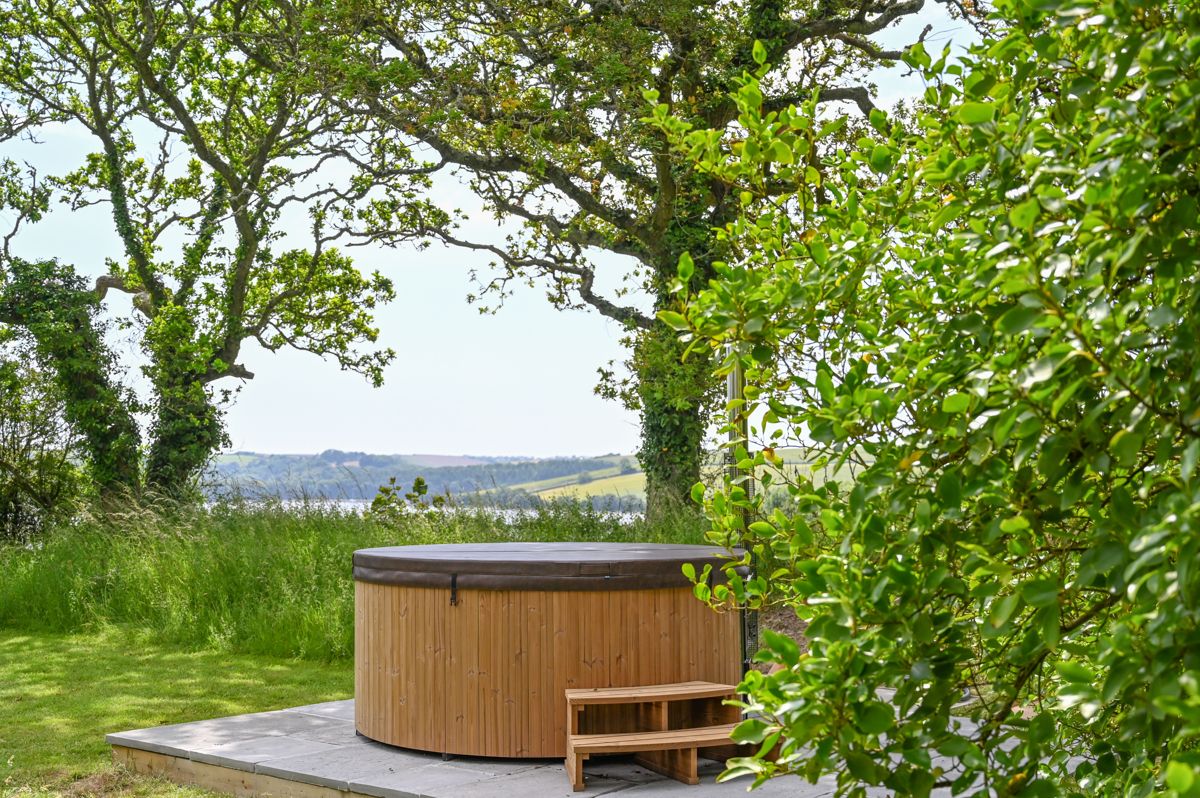 A wood-fired hot tub in a hidden corner of the garden, looking towards the river