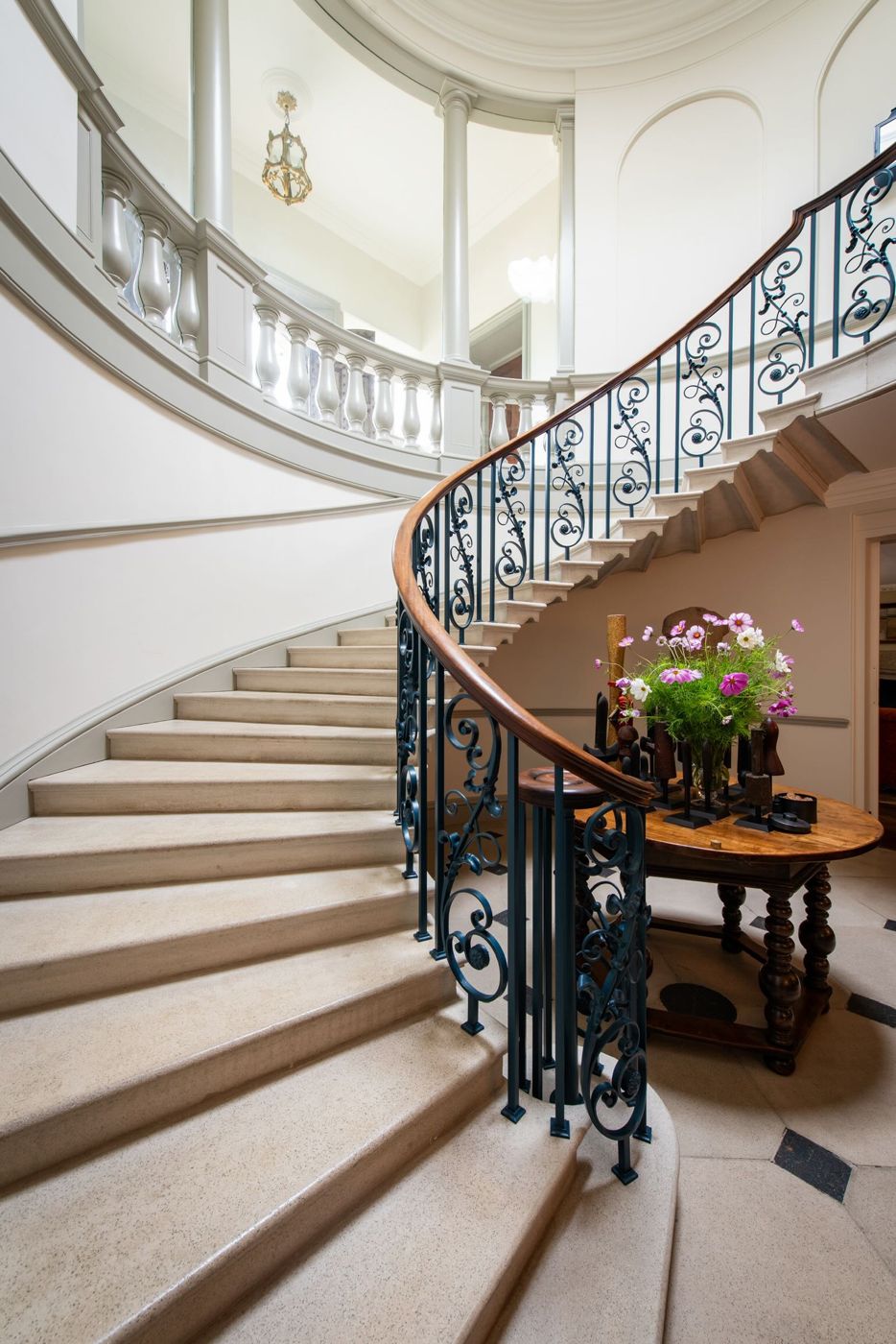 The cantilevered stone staircase rising beneath a domed lantern